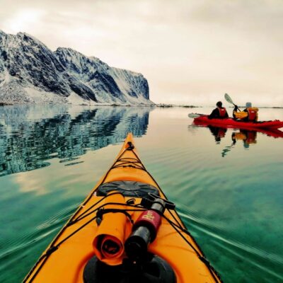 Two people kayaking at sunset during the best winter kayaking experience in Eggum, Lofoten, Norway